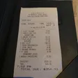 A printed dinner receipt lies in a black check presenter.
